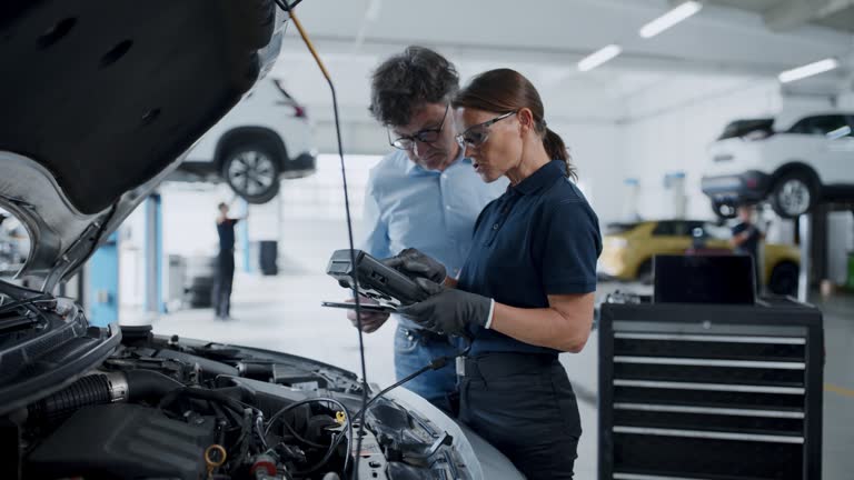 Two mechanics checking a car in a workshop